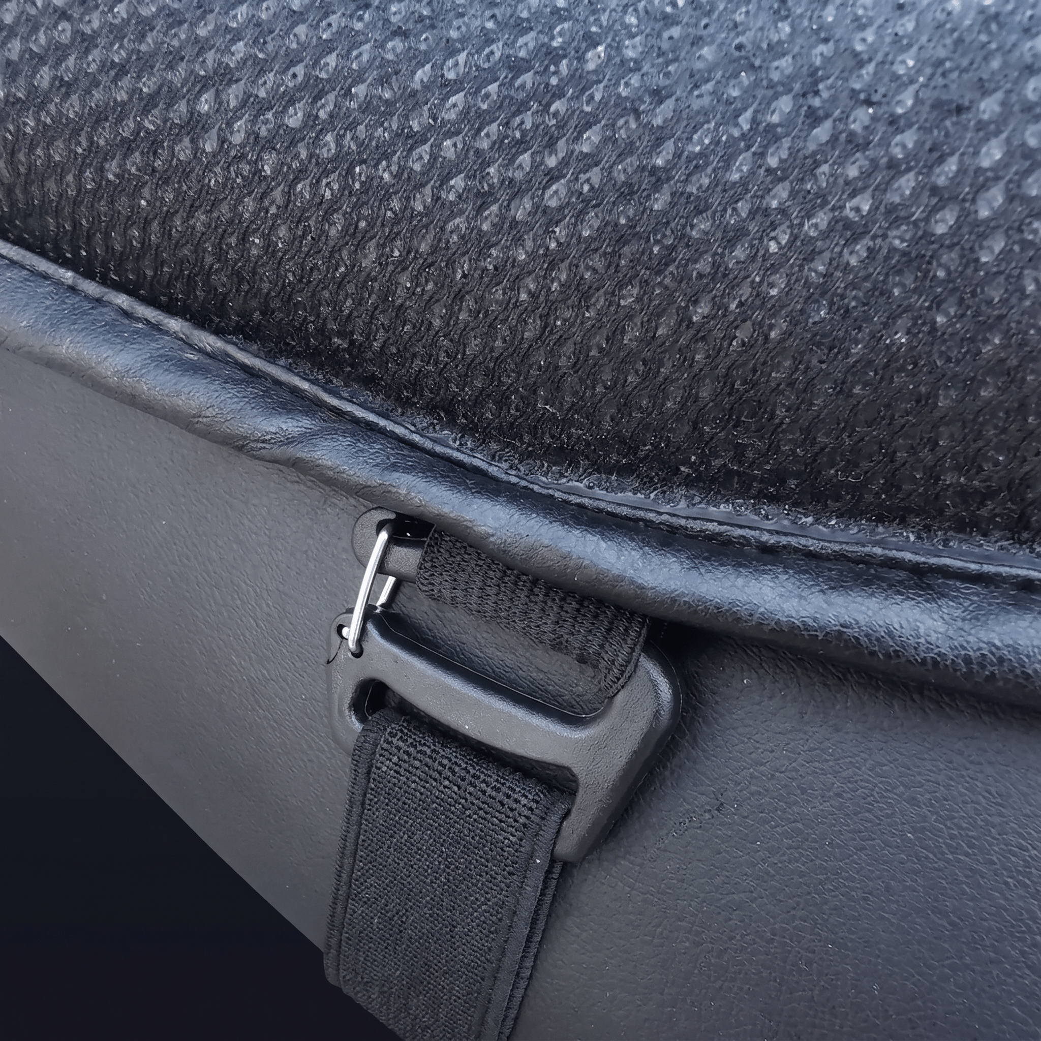 Close-up of an adjustable strap securing the cushion to a motorcycle seat